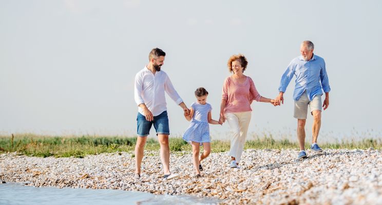 Multigenerational family walking on rocky waterside